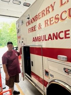 Picture of Scott McWharf standing next to the Cranberry Lake ambulance