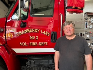 Photo of Mark Leroux in front of a Cranberry Lake fire truck