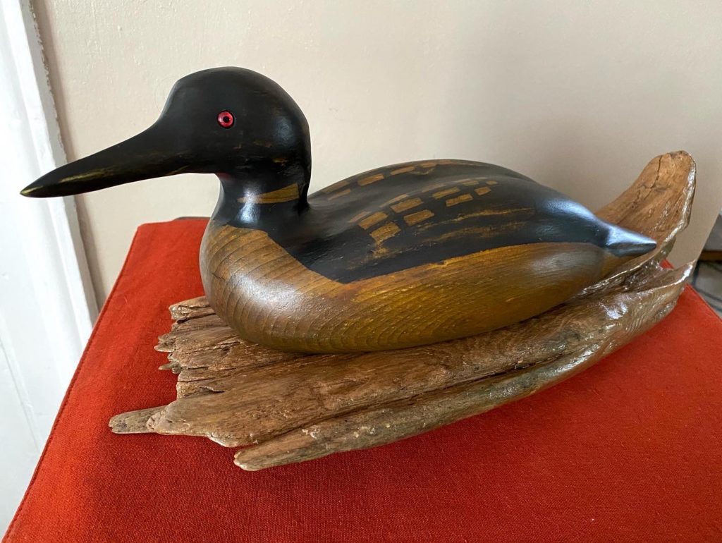 Image of wood loon, stained and mounted on driftwood