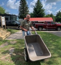 Ed Kipp pushing a wheelbarrow.