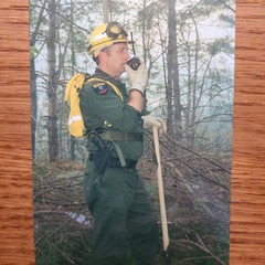 Scanned image of Bernie Siskavich in ranger uniform talking on handheld radio.